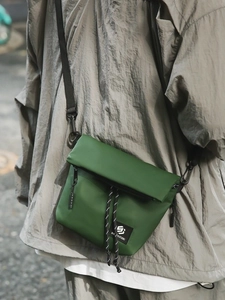 Army green nylon crossbody messenger bag with functional flap and decorative drawstring