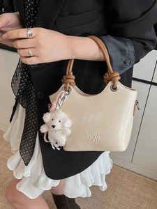 Sac seau chic en cuir beige avec anses marron et pendentif mignon en peluche de chiot