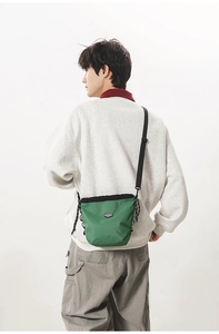 Detail of dark green checkered crossbody bag with adjustable strap and drawstring closure