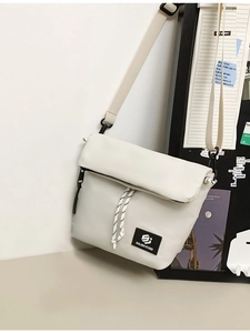 Minimalist beige nylon messenger bag with adjustable strap and black logo detail
