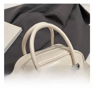 Detail of cream leather Boston bag with silver ball clasp and round top handle