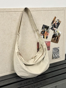 Chic beige nylon hobo bag with adjustable wide strap and subtle wrinkled texture