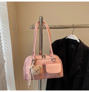Detailansicht der rosa Lackleder-Kissentasche mit flauschigem Bärenanhänger und Taschen