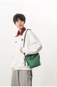 Detailed view of green checkered nylon crossbody bag with drawstring on male model