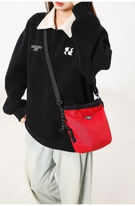 Detail of red checkered drawstring crossbody bag with adjustable strap and outdoor aesthetic