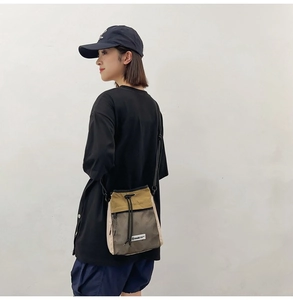 Detailansicht einer Outdoor-Kordelzug-Umhängetasche aus khakifarbenem Nylon mit Netztasche