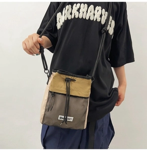 Detail der Nylon-Umhängetasche mit Kordelzug, Farbmix und praktischer Netztasche vorne