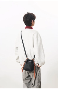 Detail of lightweight checkered nylon crossbody bag with orange drawstring on model