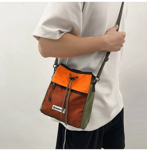 Detail der Umhängetasche mit Kordelzug aus orange-grünem Nylon mit Netztasche