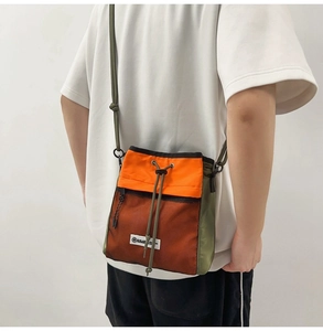 Detail einer Umhängetasche in Orange und Grün mit Mesh-Taschen und Kordelzug
