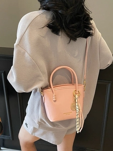 Pink contrast color bucket bag with top handles and a tennis racket charm for women