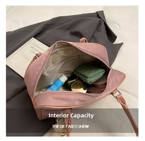 Internal capacity of mauve nylon handbag showing essentials and a zipper pocket