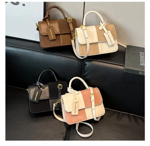 Detailed view of square handbags in multiple colors displayed on a black leather sofa