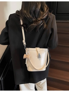 Retro cream bucket bag with silver buckle and pearl bow charm shown from behind on a model