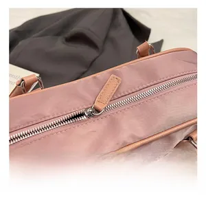 Detailed close-up of premium metal zipper and pink leather puller on the nylon pillow bag