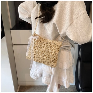 Detail of hollow woven straw bag with delicate white lace bow and fabric lining