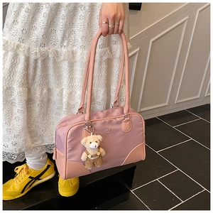 Détail du sac bowling rose avec breloque ours et logo CHLO SMU en vue de rue