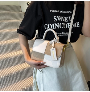 Detail of color-block flap bag with golden hardware and white decorative tag