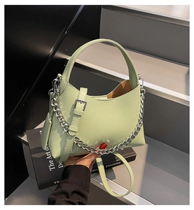Detail of light green bucket bag showing lychee texture and silver chain decoration