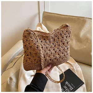 Detailed close-up of woven floral pattern and zipper closure on straw beach bag