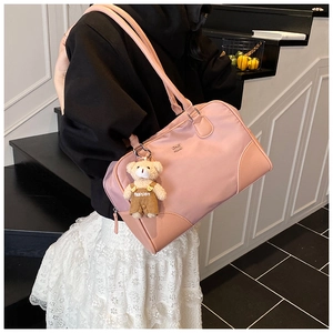 Détail du sac fourre-tout rose clair en nylon avec coins en cuir et breloque ours