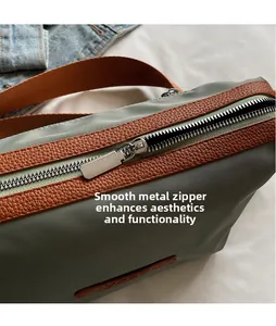 Detail of premium silver metal zipper and brown leather trim on green nylon bag