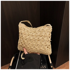 Close-up of beige woven straw bag featuring intricate cutout star pattern and sturdy texture