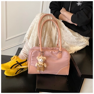 Détail du sac à main bowling en nylon rose avec logo métallique et breloque ours mignon
