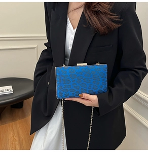 Dettaglio pochette rigida leopardata blu con tracolla a catena dorata e cornice in metallo
