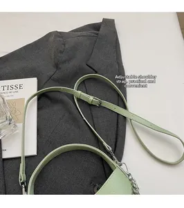 Detail of adjustable leather strap and silver chain on mint green litchi texture bucket bag