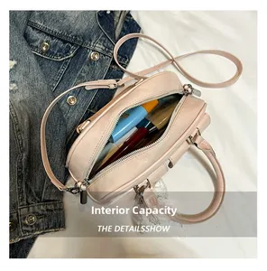 Internal capacity of light pink crossbody bowling bag showing cosmetics and storage