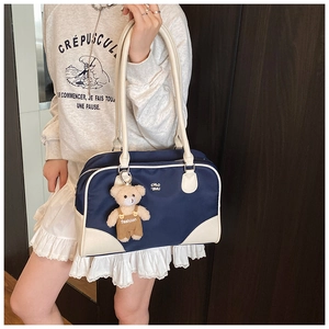 Détail du sac bowling en nylon bleu marine avec finitions contrastées et pendentif ours
