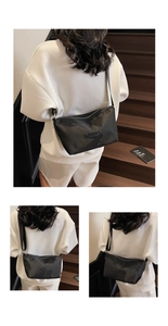 Detailansicht einer schwarzen Nylon-Umhängetasche am Model mit verstellbarem Gurt und Schnalle