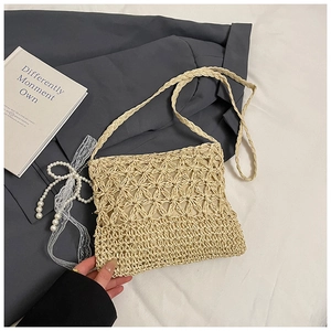 Macro shot of the beige hollowed-out handwoven straw bag with detailed geometric patterns