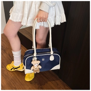 Détails du sac bowling bleu marine avec charme d'ours et poignées contrastées