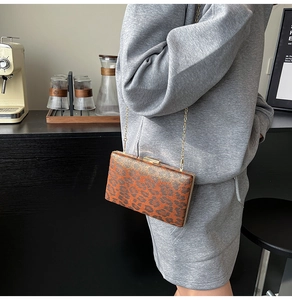 Dettaglio pochette con stampa leopardata e catena dorata sulla spalla della modella