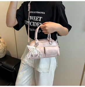 Detailed view of pink patent leather bowling bag with lace bow and pearl pendant charm