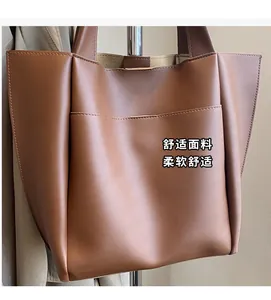 Detail view of brown faux leather tote bag with exterior pocket and neat stitching