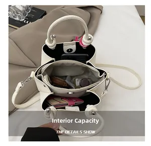 Detailed interior view of cream white crossbody bucket bag with multi-compartment storage