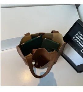 Top view of spacious brown leather tote bag interior with tablet and daily essentials