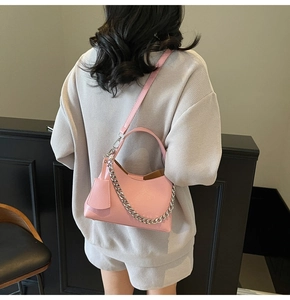 Pink lychee texture bucket bag detail with silver metal chain on a female model