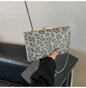 Dettaglio della pochette leopardata grigia con cornice dorata e tracolla a catena