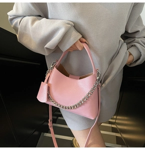 Detail of pink lychee textured bucket bag with silver chain strap and leather tag