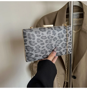 Dettaglio della pochette da sera leopardata con un'elegante chiusura in metallo dorato