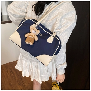 Détail du sac bowling en nylon bleu marine avec finitions cuir et charme d'ours