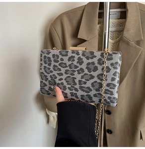 Dettaglio di pochette leopardata con catena dorata su un elegante blazer casual