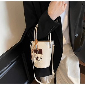 Detail of cream bucket bag with lace bow and adjustable PU leather shoulder strap
