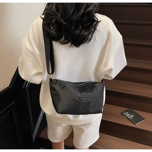 Moderne schwarze Nylon-Umhängetasche mit verstellbarem Riemen und Silberbeschlägen