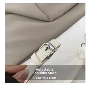 Close-up of white lychee pattern leather adjustable shoulder strap with silver metal buckle