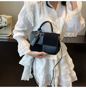 Detail shot of the black patchwork shoulder bag featuring matte and smooth textures